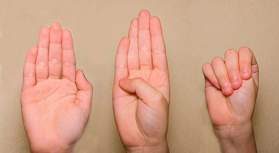 three hands demonstrate the domestic violence hand gesture