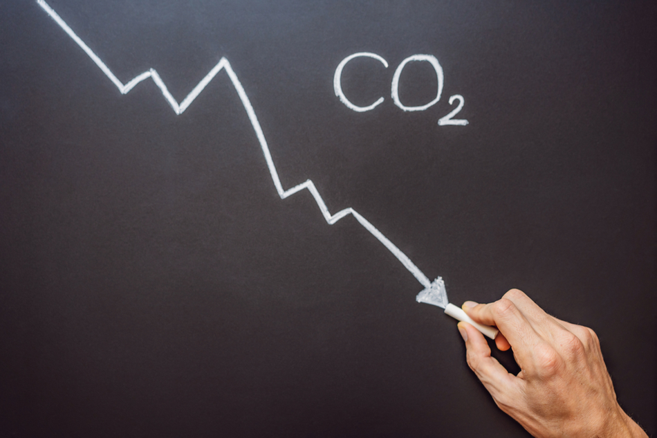 co2 line graph being drawn in decline on a chalk board