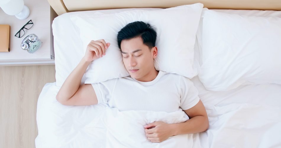 Overhead view of young asian man sleeping well and relaxing in the morning.