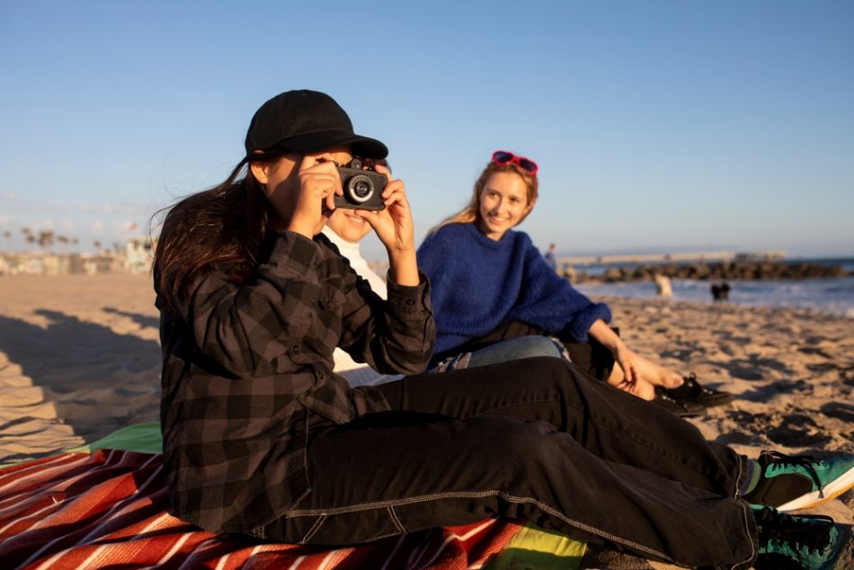 Teens with a camera at the beach