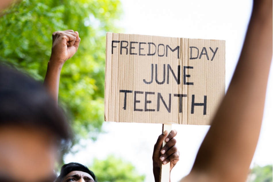 concept of Juneteenth freedom day march showing by close up protesting hands sign board