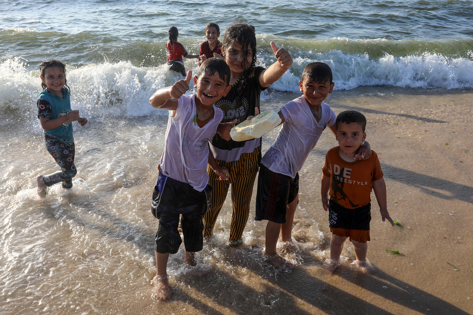Palestinian kids have fun on a beach on Gaza Strip during a hot weather