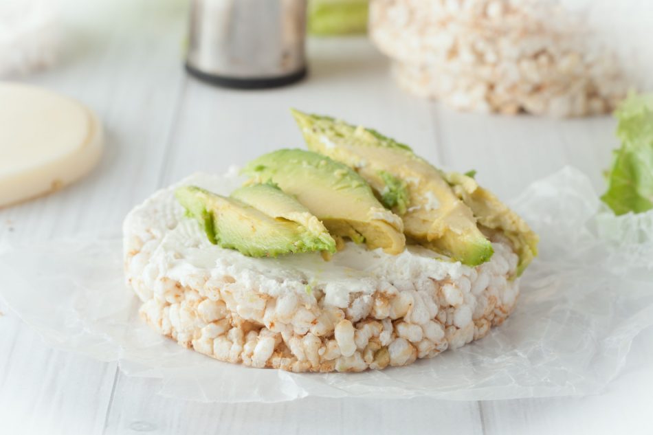 rice cake with cream cheese and avocado on white background