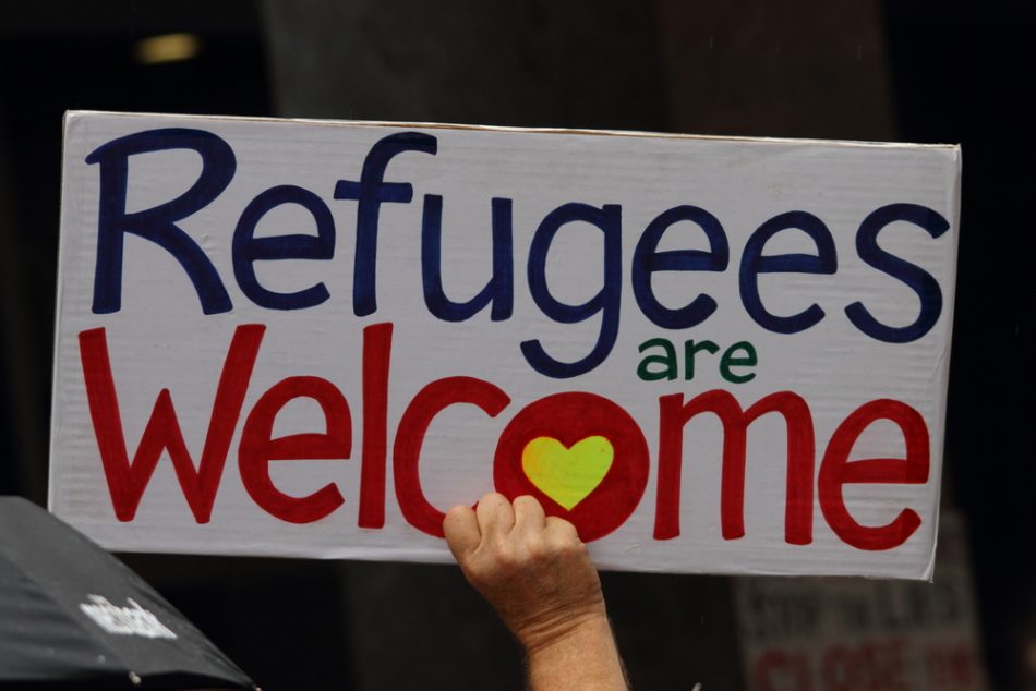 Protest sign in support of churches offering sanctuary to refugees.