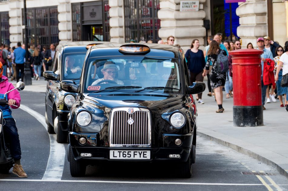 A black cab driving through London.