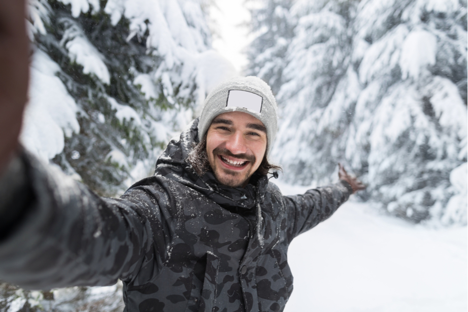 Smiling man takes a selfie in winter landscape