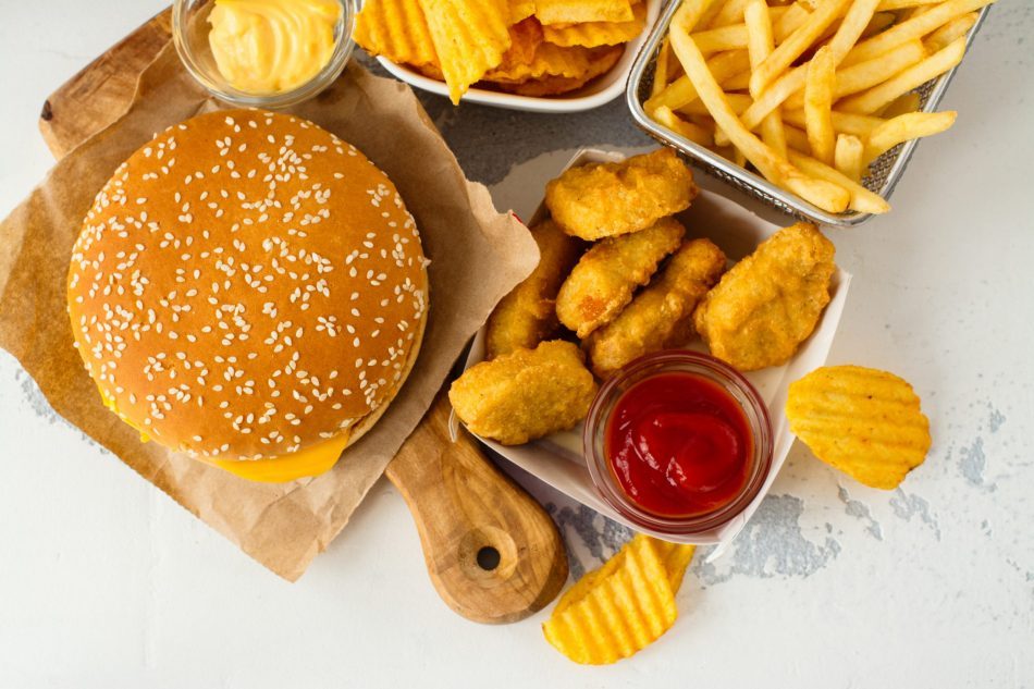 view of a burger, fries, and other junk foods from above