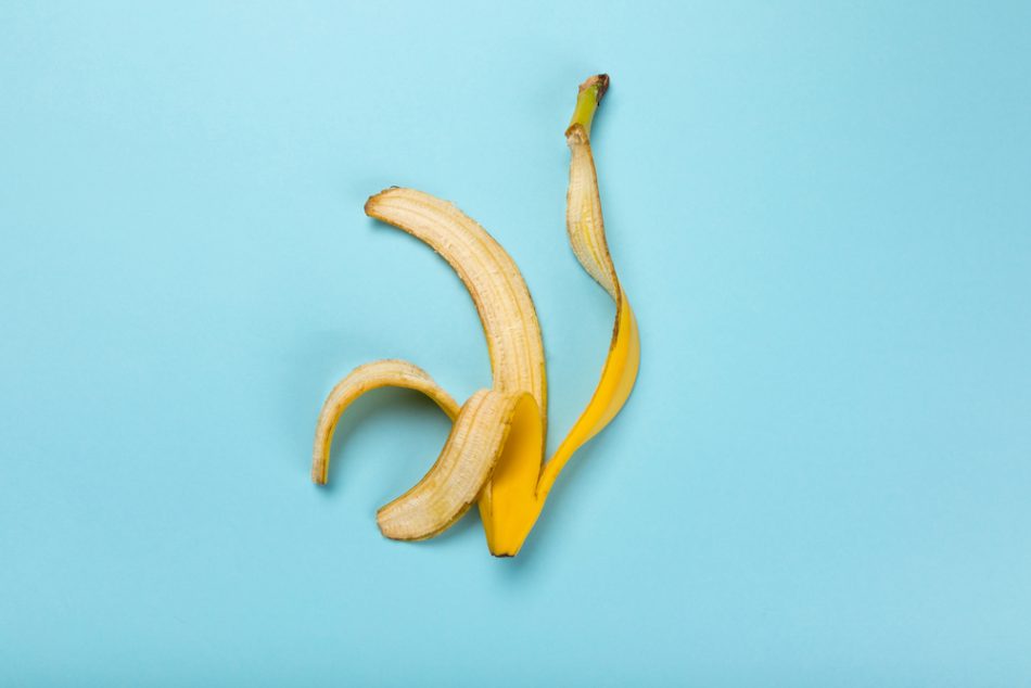 Top view of yellow banana peel isolated on blue, colorful background.