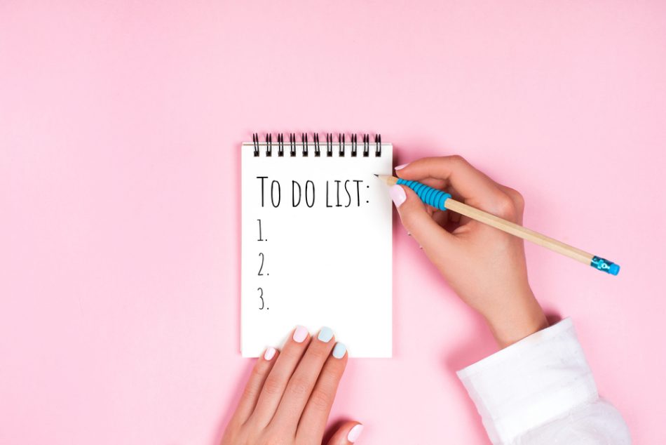 To do list on spiral notepad in front of pink background.
