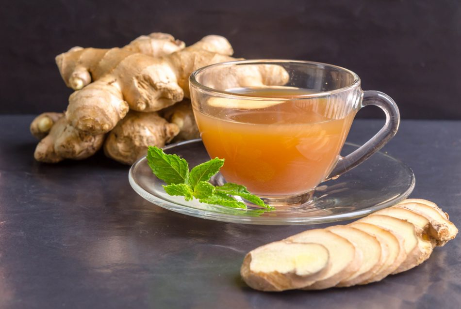 Warm cup of ginger tea with ginger next to it