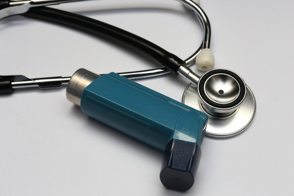 A stethoscope and blue asthma inhaler isolated on white background.