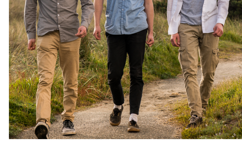 shot of three pairs of men's legs walking together in nature