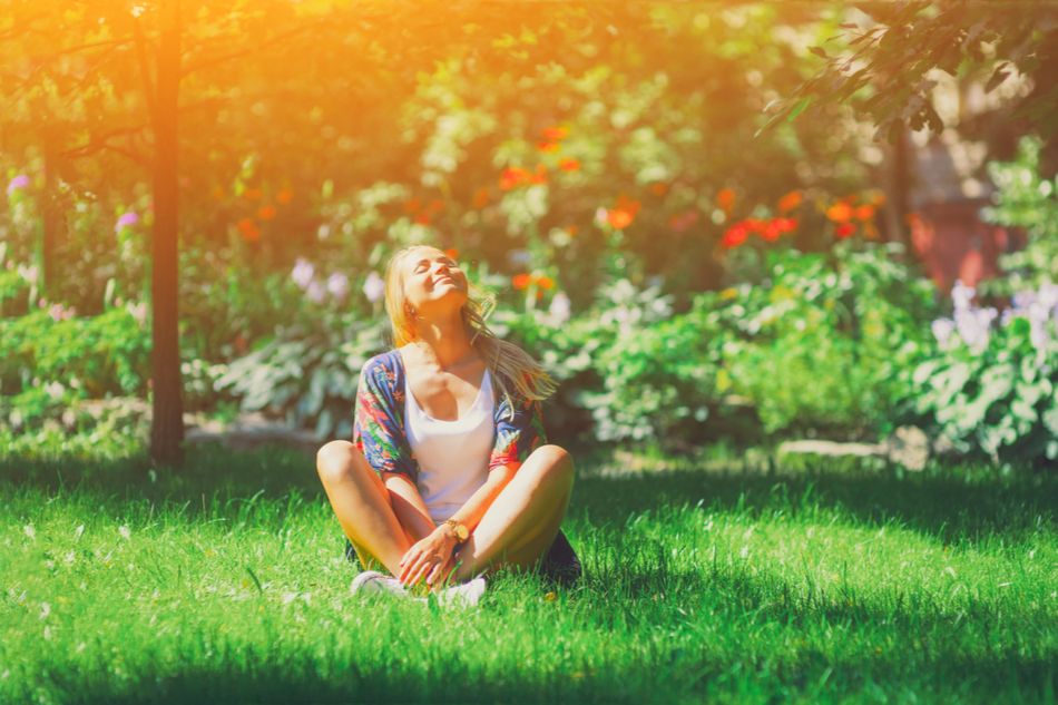 Young woman siting on grass in the sun